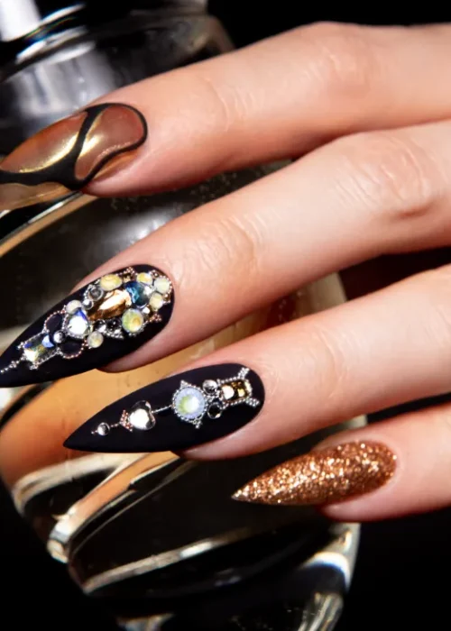A black and gold nail art with diamonds and color colors.