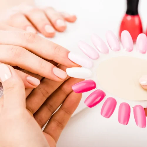 A manicurist holding a nail polish palette for the customer to like.