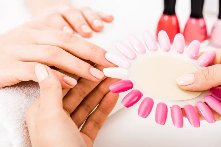 A manicurist holding a nail polish palette for the customer to like.